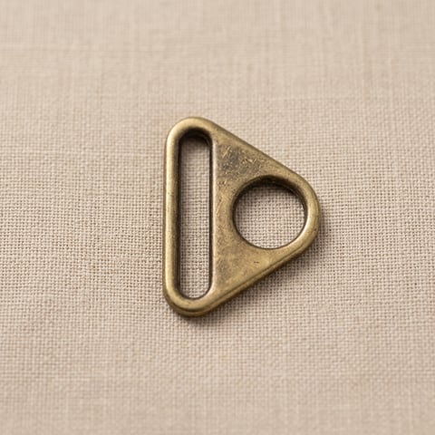 Antique brass triangle ring on linen