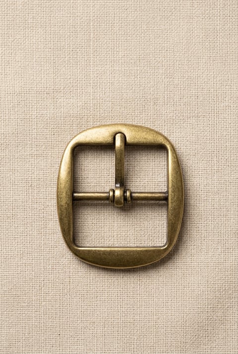 Antique brass oval frame footwear buckle on linen