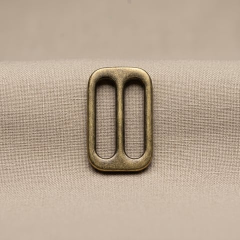 Antique brass double-slot slider on linen