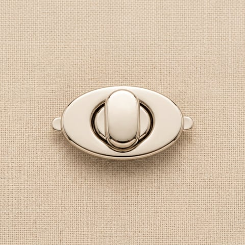 Polished nickel oval turn-lock clasp on linen