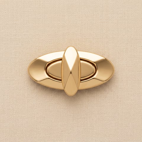 Polished gold oval turn-lock clasp on linen