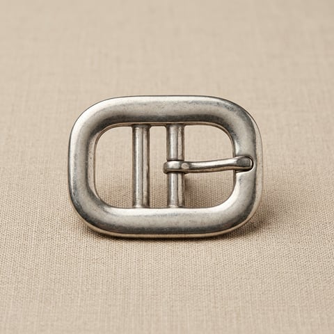 Antique silver oval double-bar belt buckle on linen