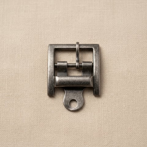 Antique nickel lug-plate roller footwear buckle on linen