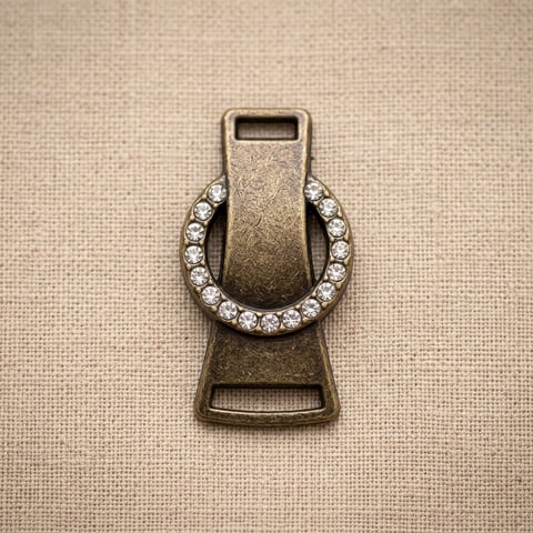 Antique brass crystal ring strap ornament on linen
