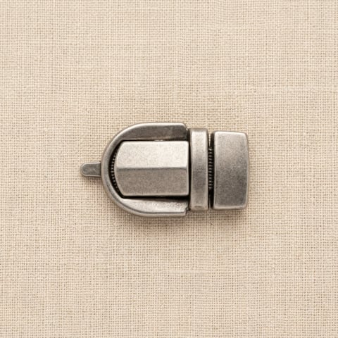 Antique silver tuck lock bag closure on linen