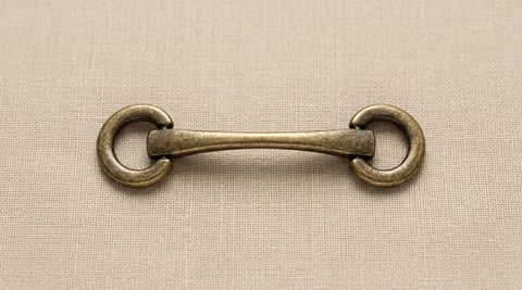 Antique brass bar and ring bag connector on linen