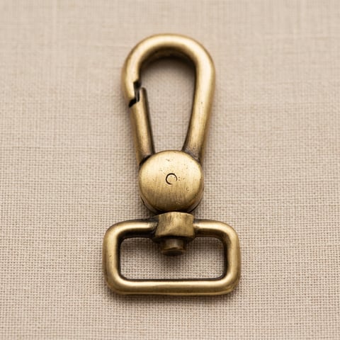 Antique brass square-loop swivel snap hook on linen