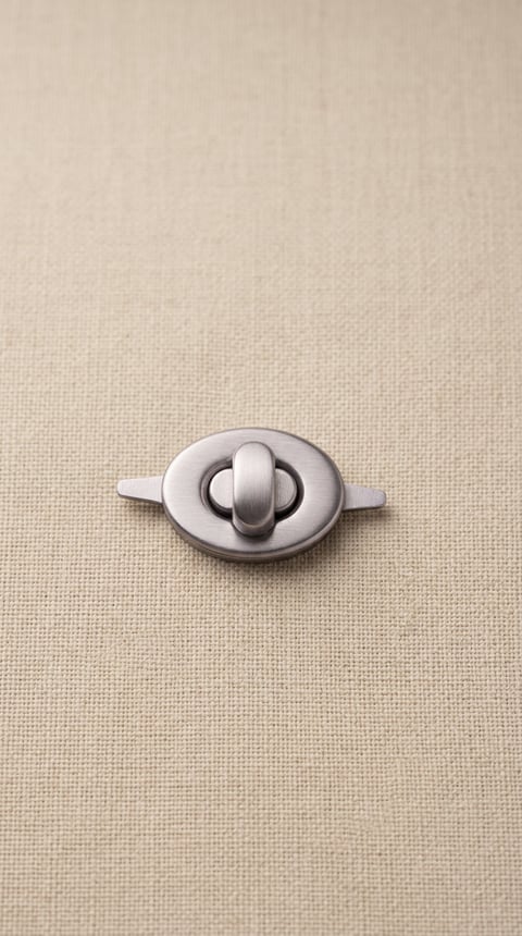 Satin nickel oval turn-lock bag closure on linen