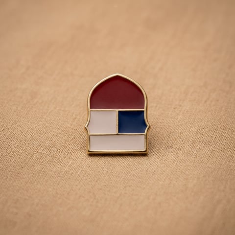 Gold enamel arch shoe ornament on linen