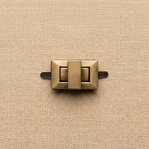 Antique brass rectangular turn clasp bag fitting on linen