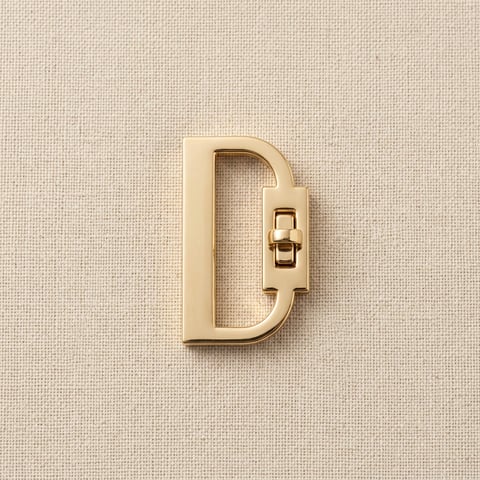 Polished gold D-shaped turn-lock bag clasp on linen