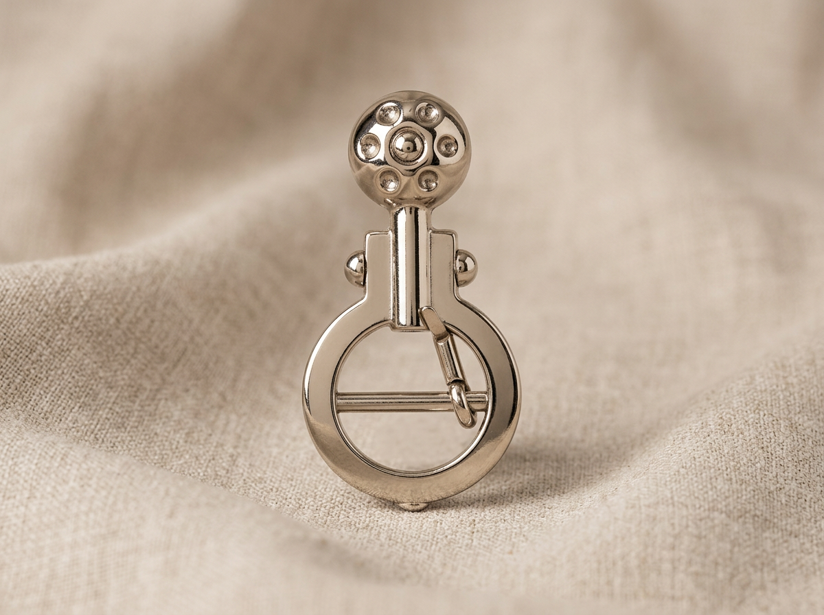 Ornate polished nickel scroll hook on linen