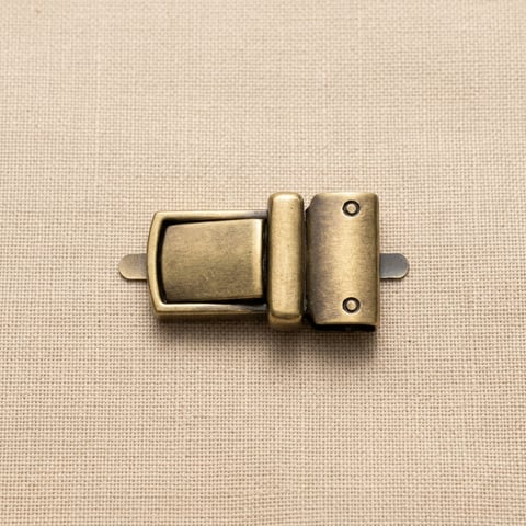 Antique brass flip clasp bag fitting on linen